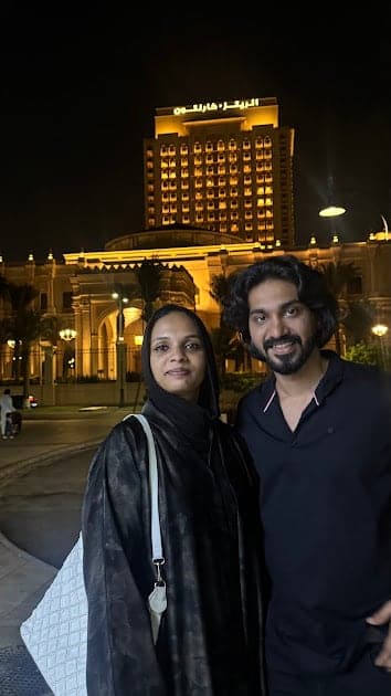 Fazna and Nisham at night with a lit tower behind them