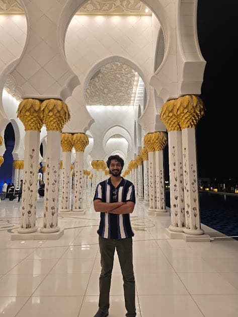 Nisham in a white marble hall with gold columns